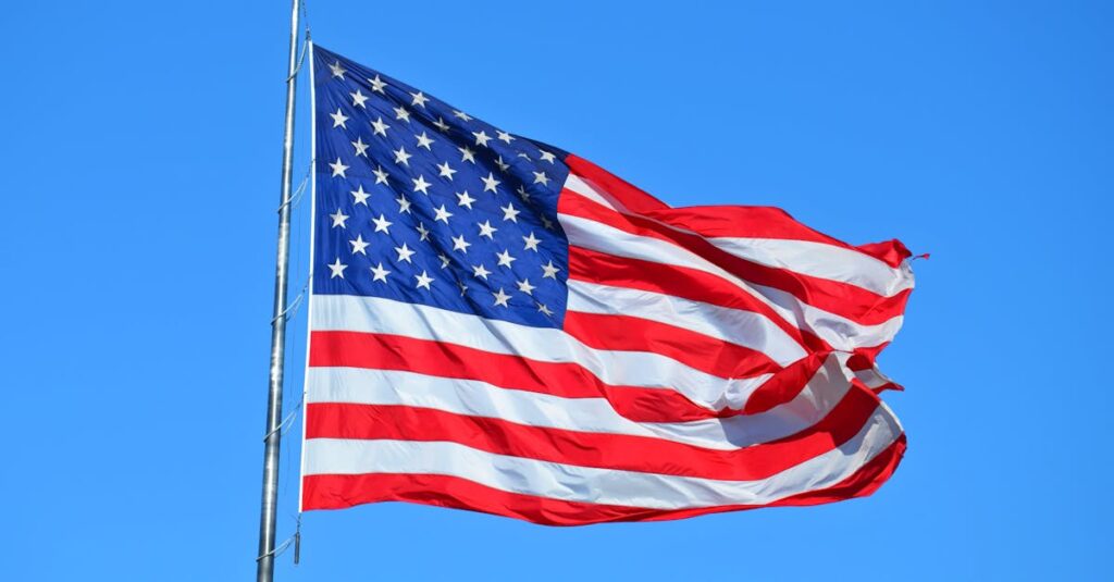 Majestic American flag waving against a bright blue sky, symbolizing freedom and patriotism.